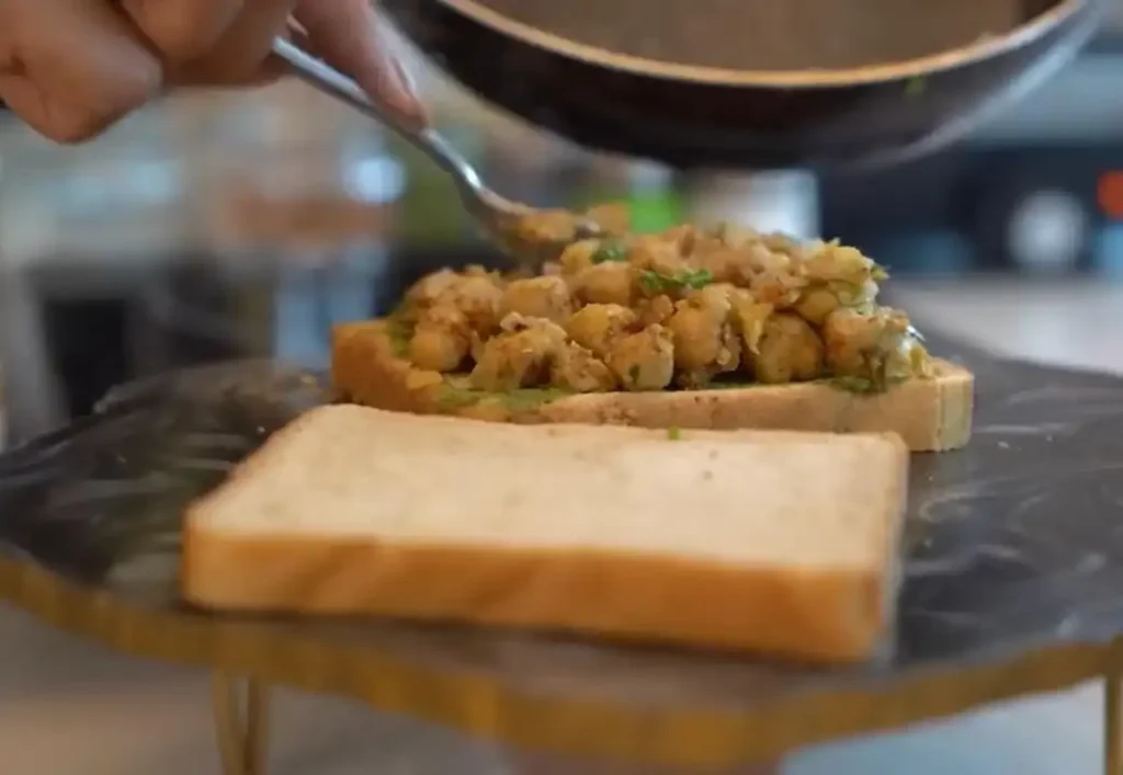 spreading filling on chickpea sandwich