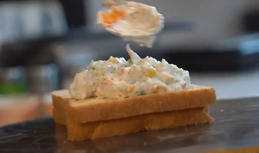 spreading filling on hung curd sandwich