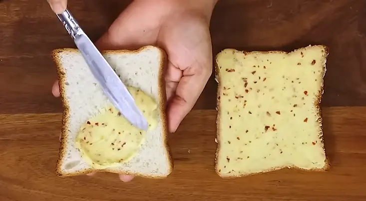 applying garlic butter on bread