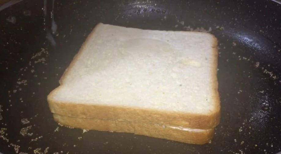 placing sandwich in pan for cooking