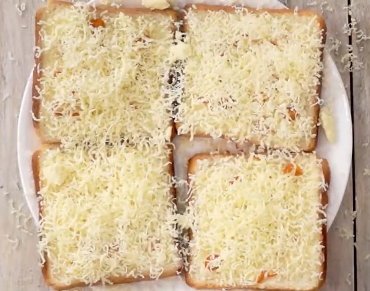 more grated cheese on bread