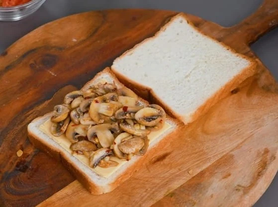 spread mushroom stuffing on bread slices