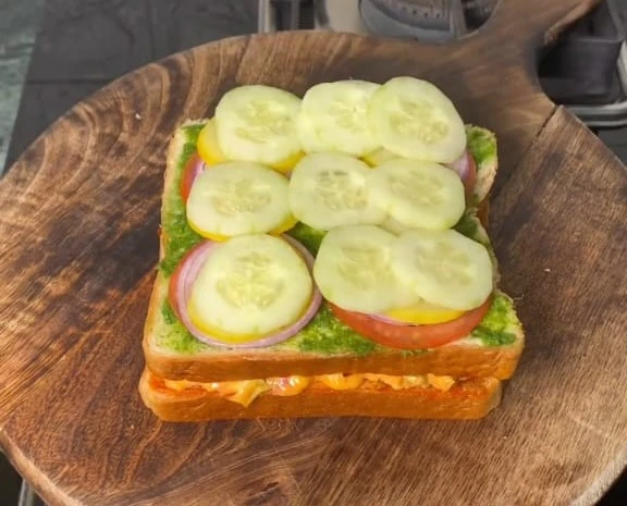 placing the chopped onion, tomato, cucumber over bread